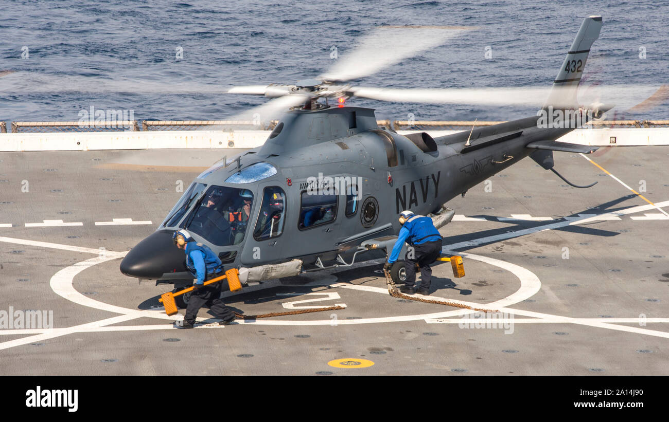 Sailors chock and chain a Philippine Navy AW109 helicopter. Stock Photo