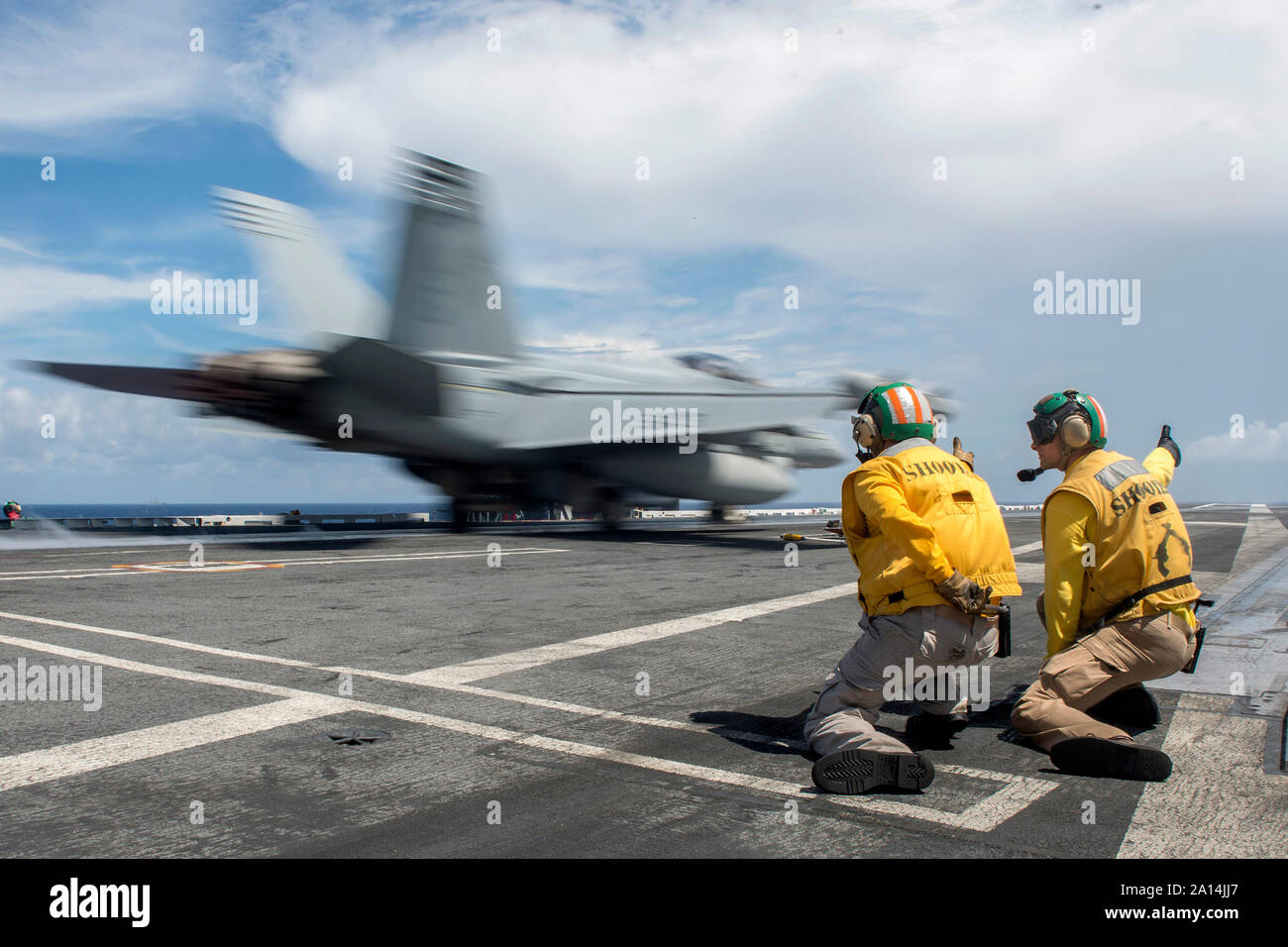 U.S. Navy shooters signal to launch an EA-18G Growler . Stock Photo