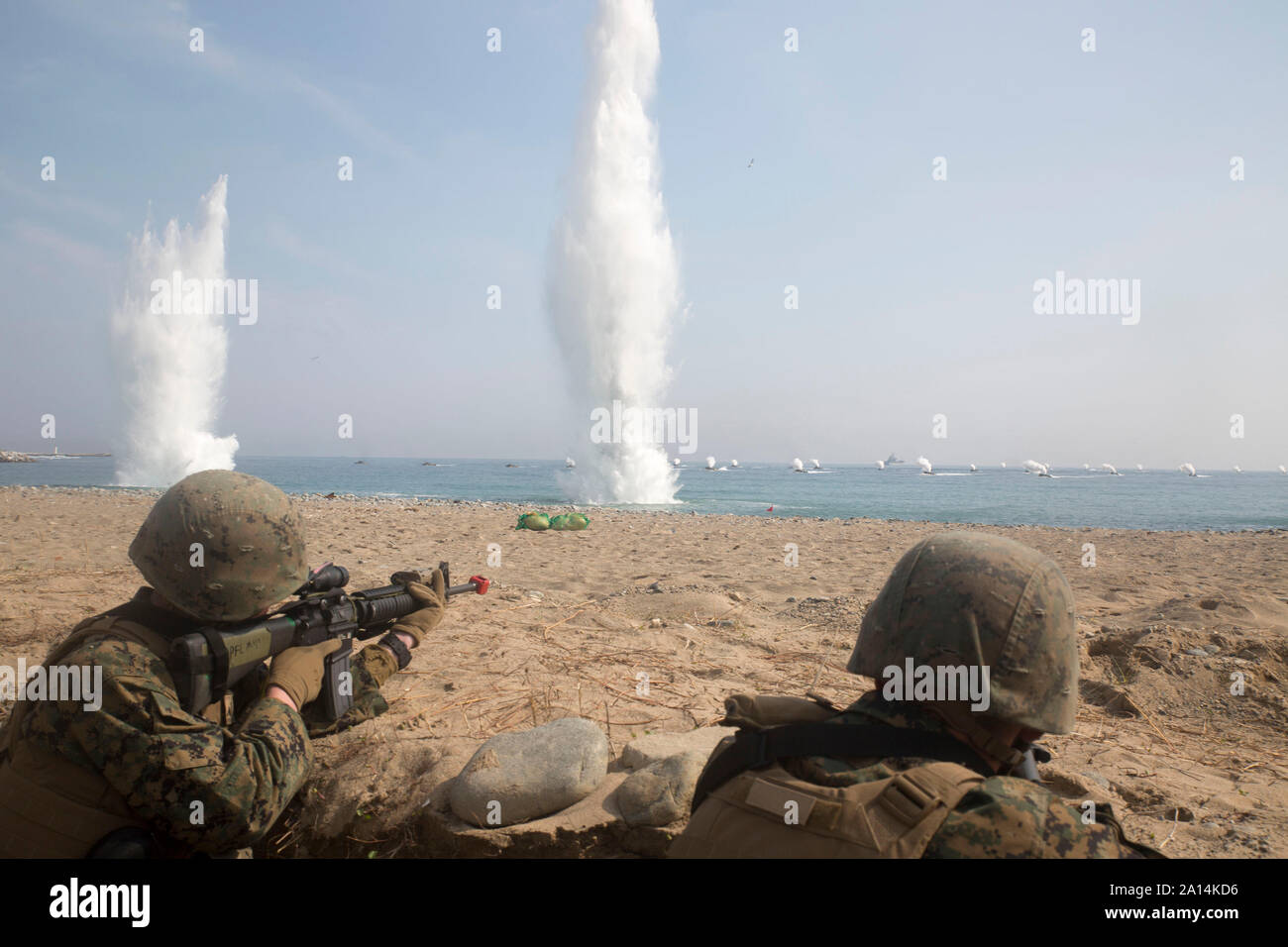 U.S. Marines training on a beach in Pohang, Republic of Korea, as explosive charges detonate. Stock Photo