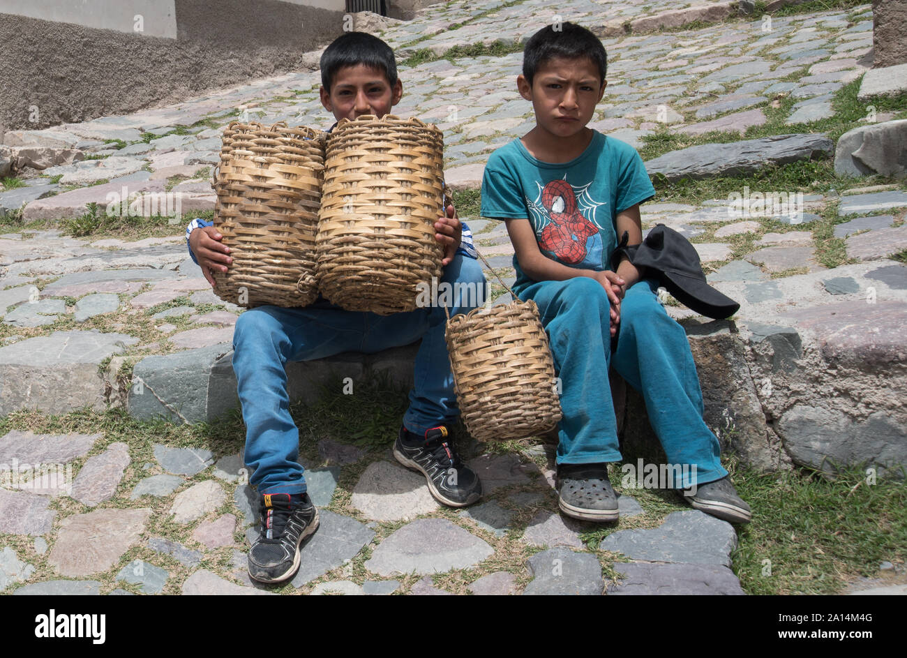 Iruya, Argentina - March 06 2017: Kids selling figs in the streets of an old town hiden inside the mountains in the province of Salta. Stock Photo