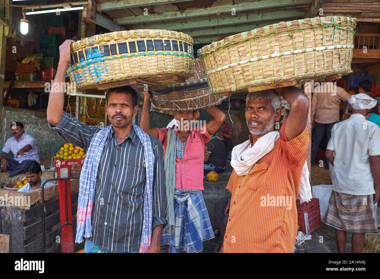 Three porters in Byculla Market, a wholesale fruit and vegetable market