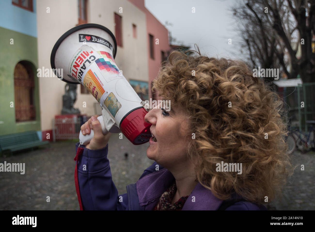 Buenos Aires, Argentina - July 31 2016: Rainy days in the neighborhood of La Boca. A woman speaker advertising and promoting a play with a megaphone. Stock Photo