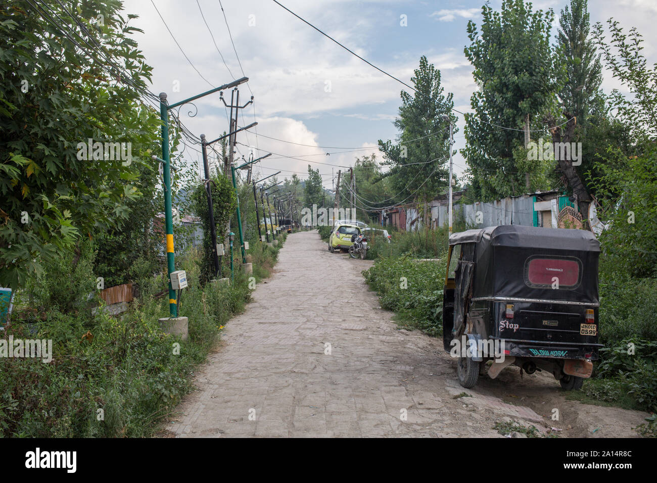 A rickshaw on empty lakeside road in the capital of Kashmir. Stock Photo