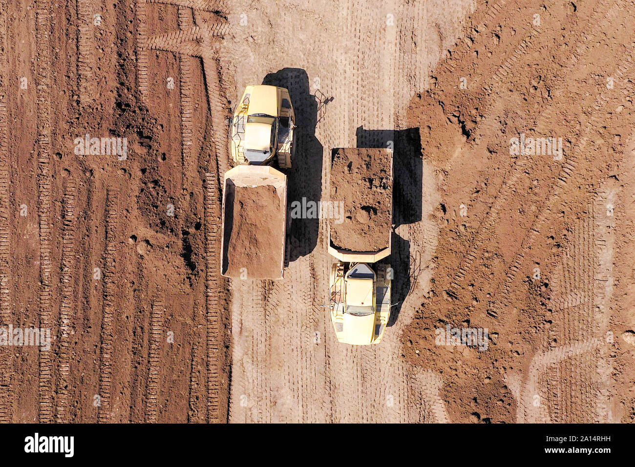 Articulated hauler Truck loaded with Soil at an industrial development site, Topdown aerial image. Stock Photo