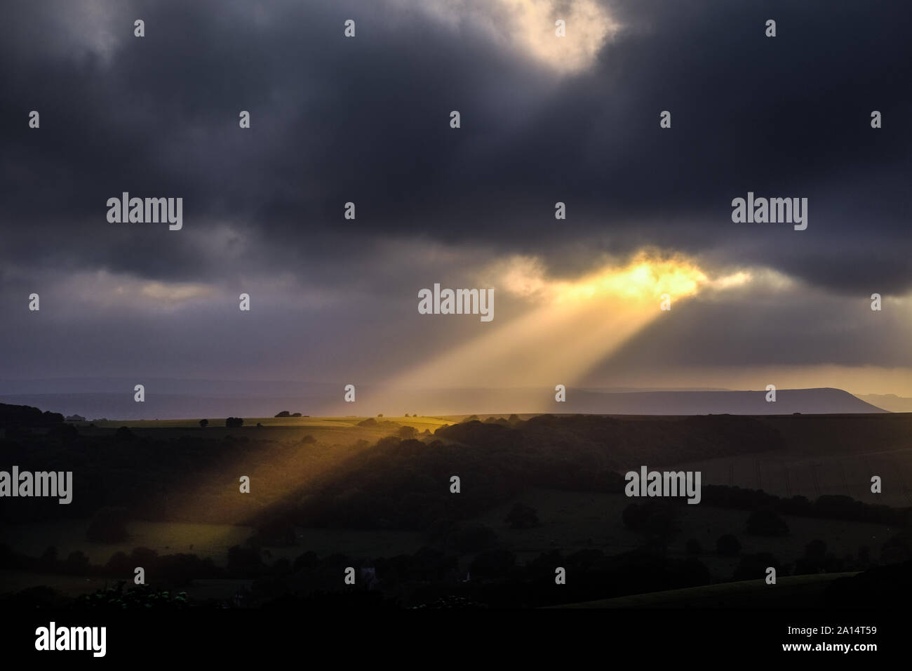 Sunbeams breaking through the clouds over downland Stock Photo