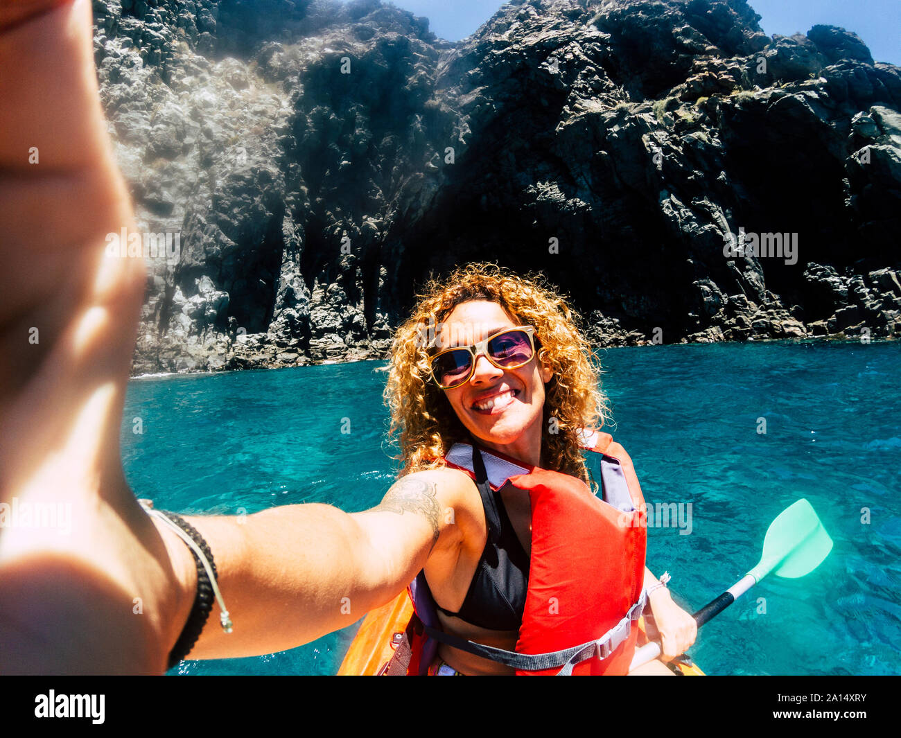 Cheerful people happy smiling female take selfie picture with kayak having outdoor leisure sport activity in the blue ocean water - concept of hapines Stock Photo