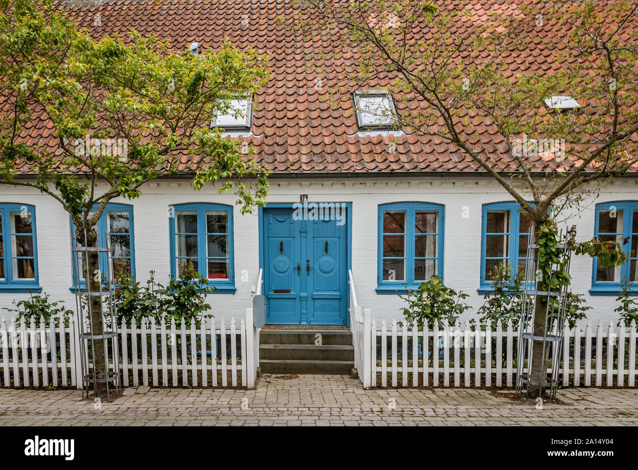 Old danish house with blue windows and a white fence in the island of Aero, Ærøskøbing , Denmark