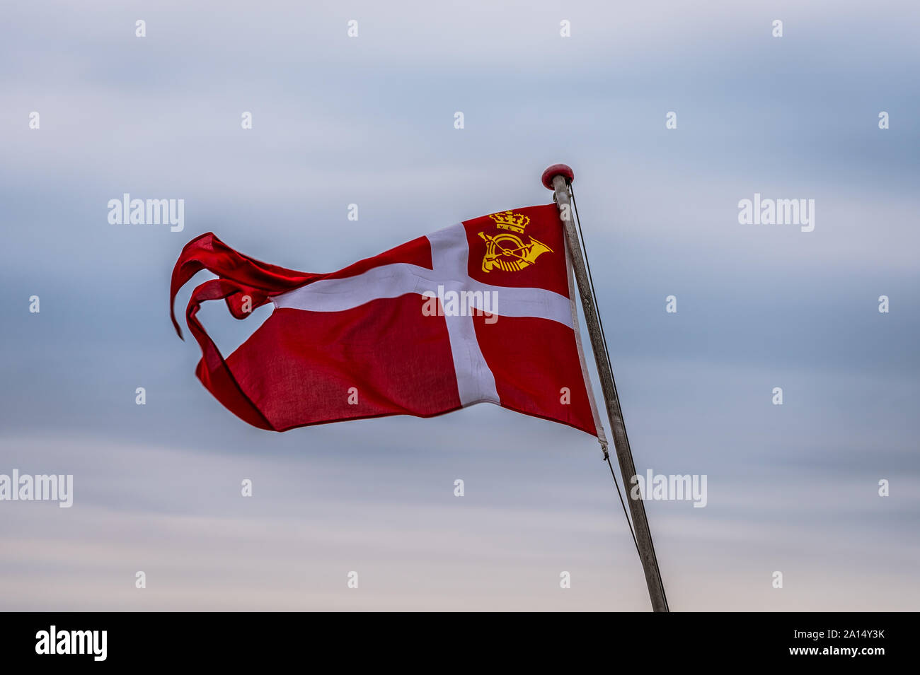 The official swallow-tailed Danish Post Flag, the Dannebrog, against the soft sky, Svendborg, Denmark, July 13, 2019 Stock Photo