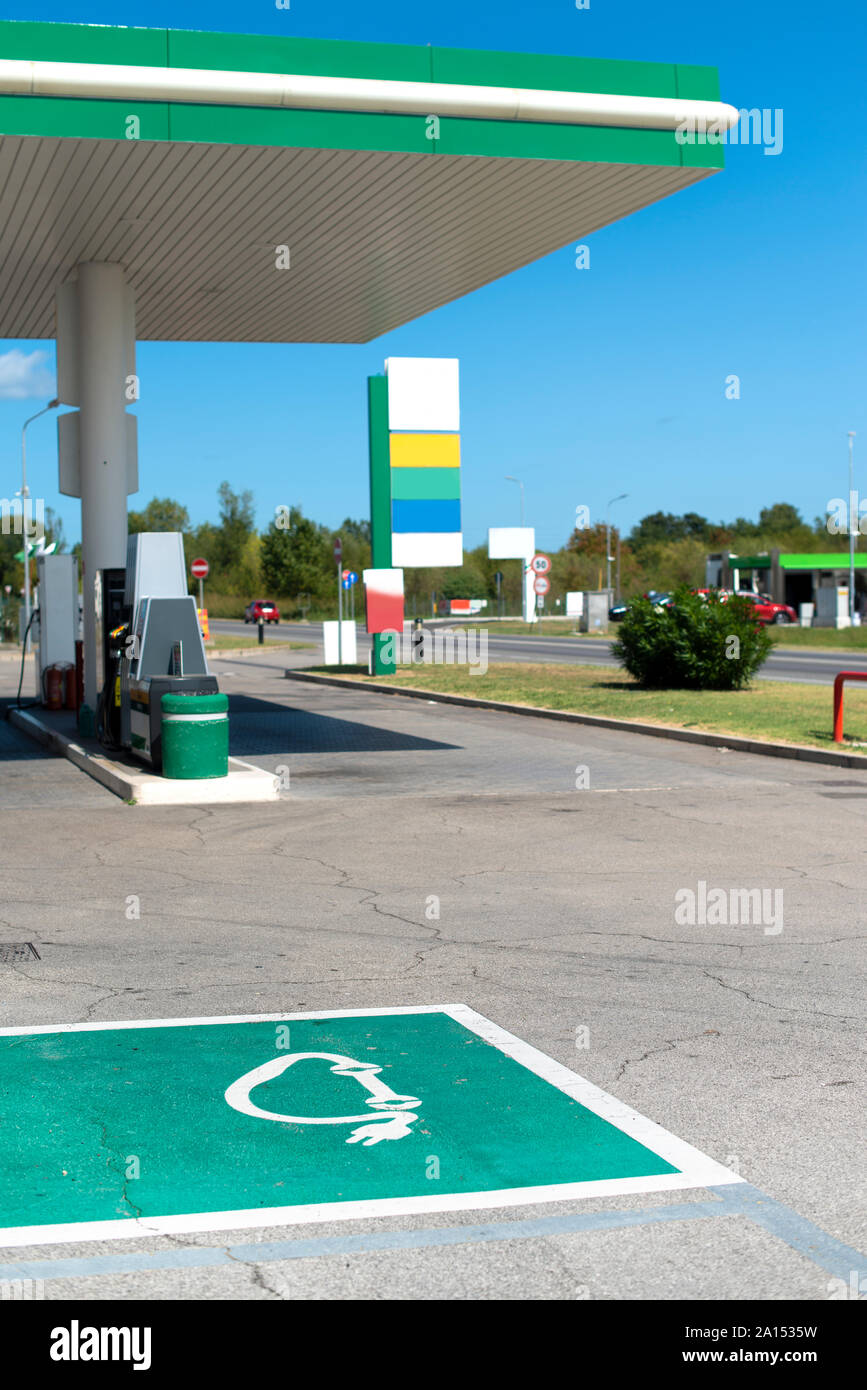 Electric charge station. Electric plug for charging cars. Car charging symbol painted on asphalt. Stock Photo