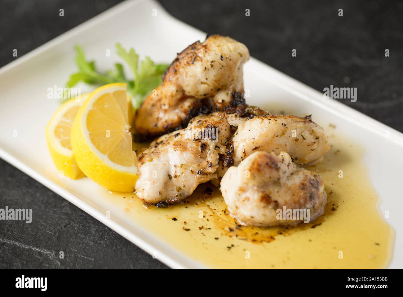 Ray cheeks that have been fried in butter, garlic and herbs with chopped capers. Ray cheeks are sometimes called skate knobs and were once common in f Stock Photo