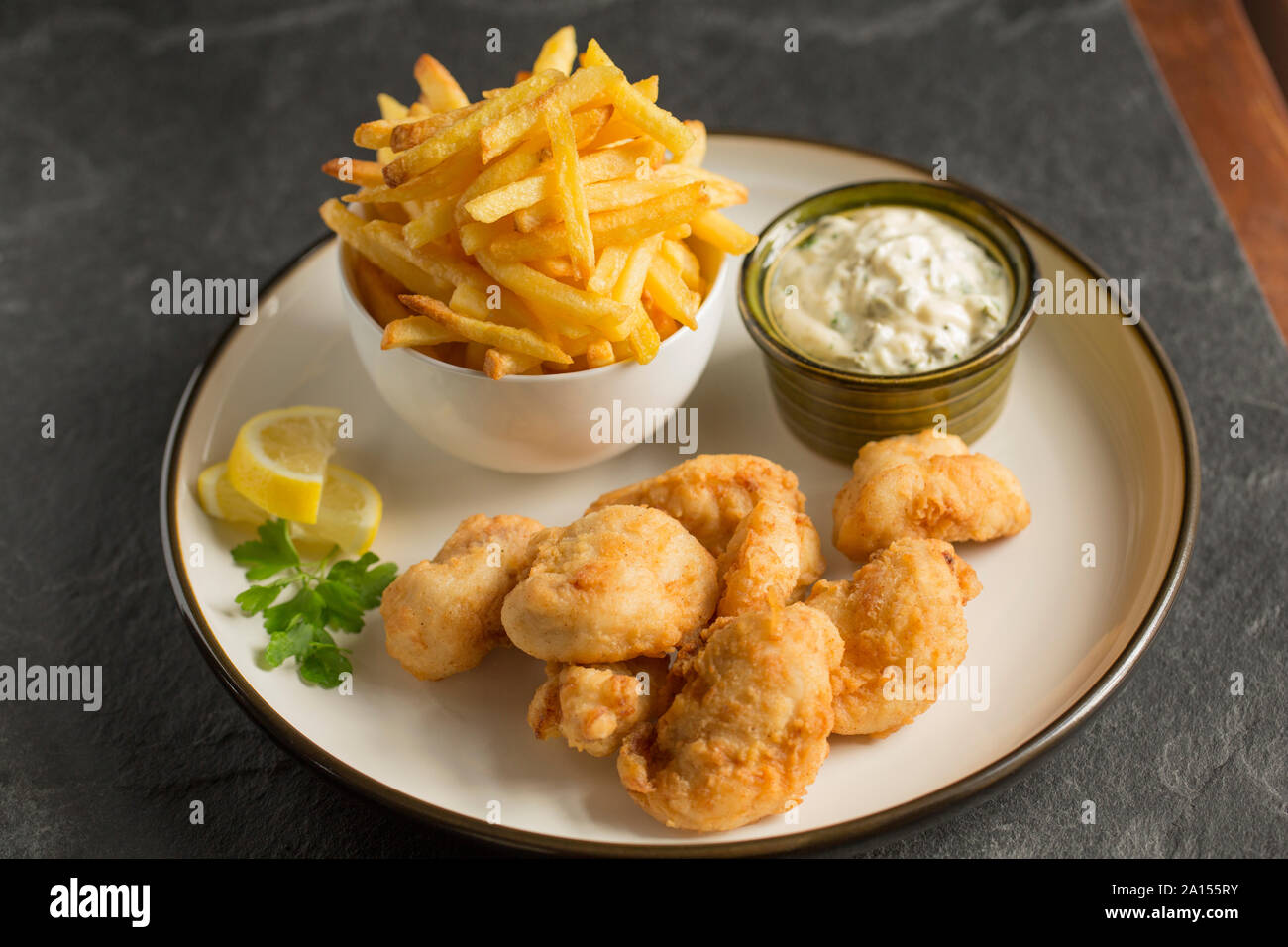 Ray cheeks that have been coated in flour and deep fried and served with chips and garlic, caper and parsely mayonnaise. Ray cheeks are sometimes call Stock Photo