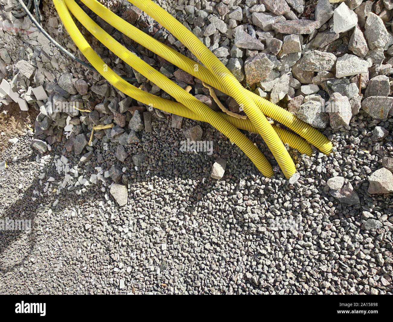 Yellow pipes for electric cables or water sticking from the ground at construction site Stock