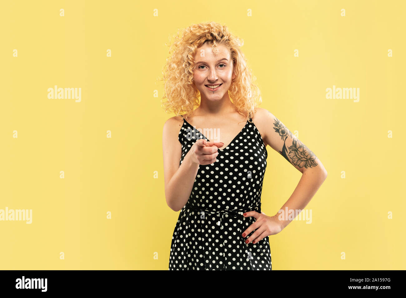 Caucasian young woman's half-length portrait on yellow studio ...