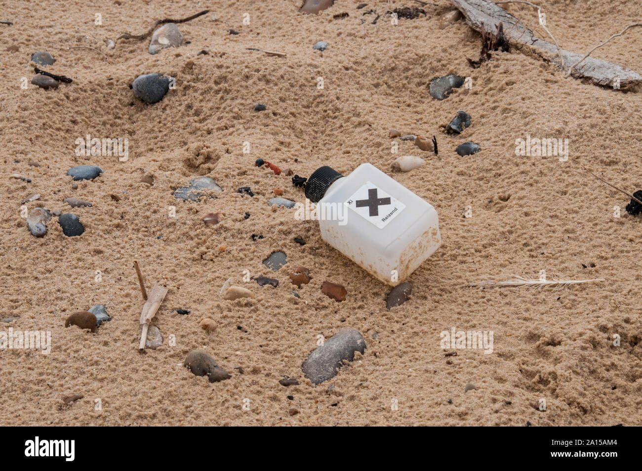 A plastic bootle with a hazard label found washed up on a Suffolk beach Stock Photo