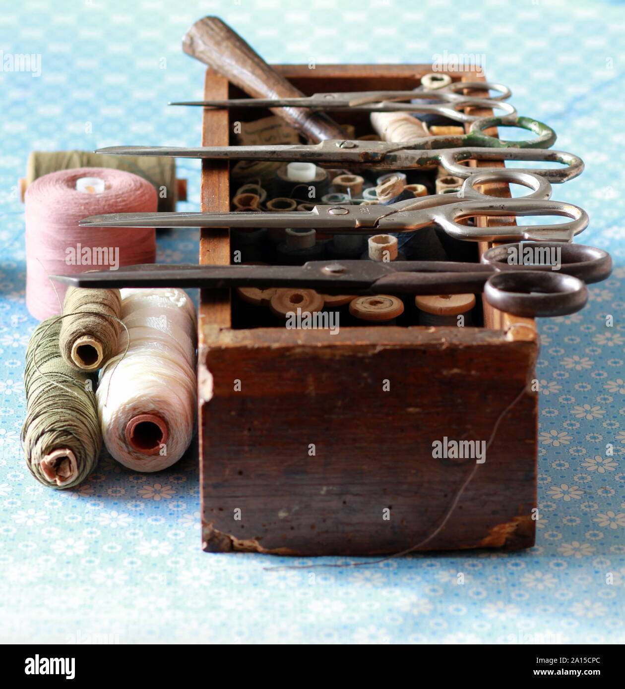 Sewing box with many thread spools and vintage scissors. Tailor occupation concept Stock Photo