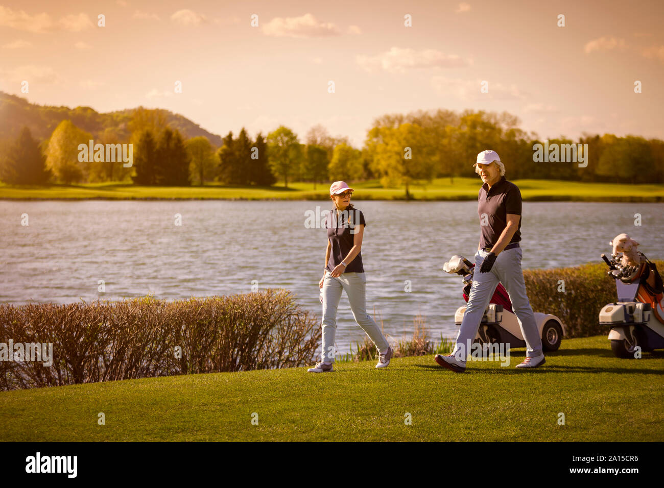 Senior couple walking on golf course. Stock Photo