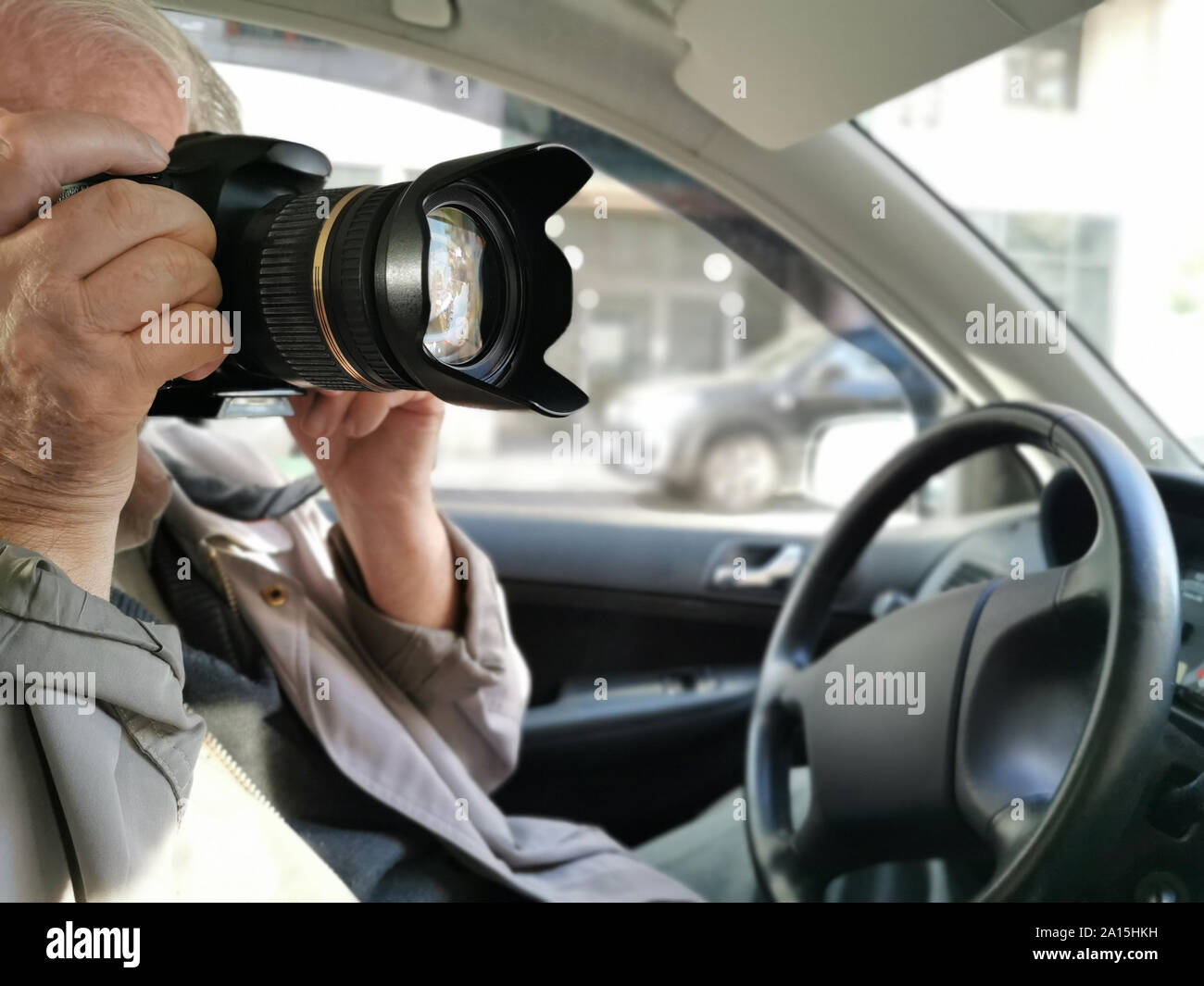 Private investigator with digital camera making photographs in car closeup Stock Photo