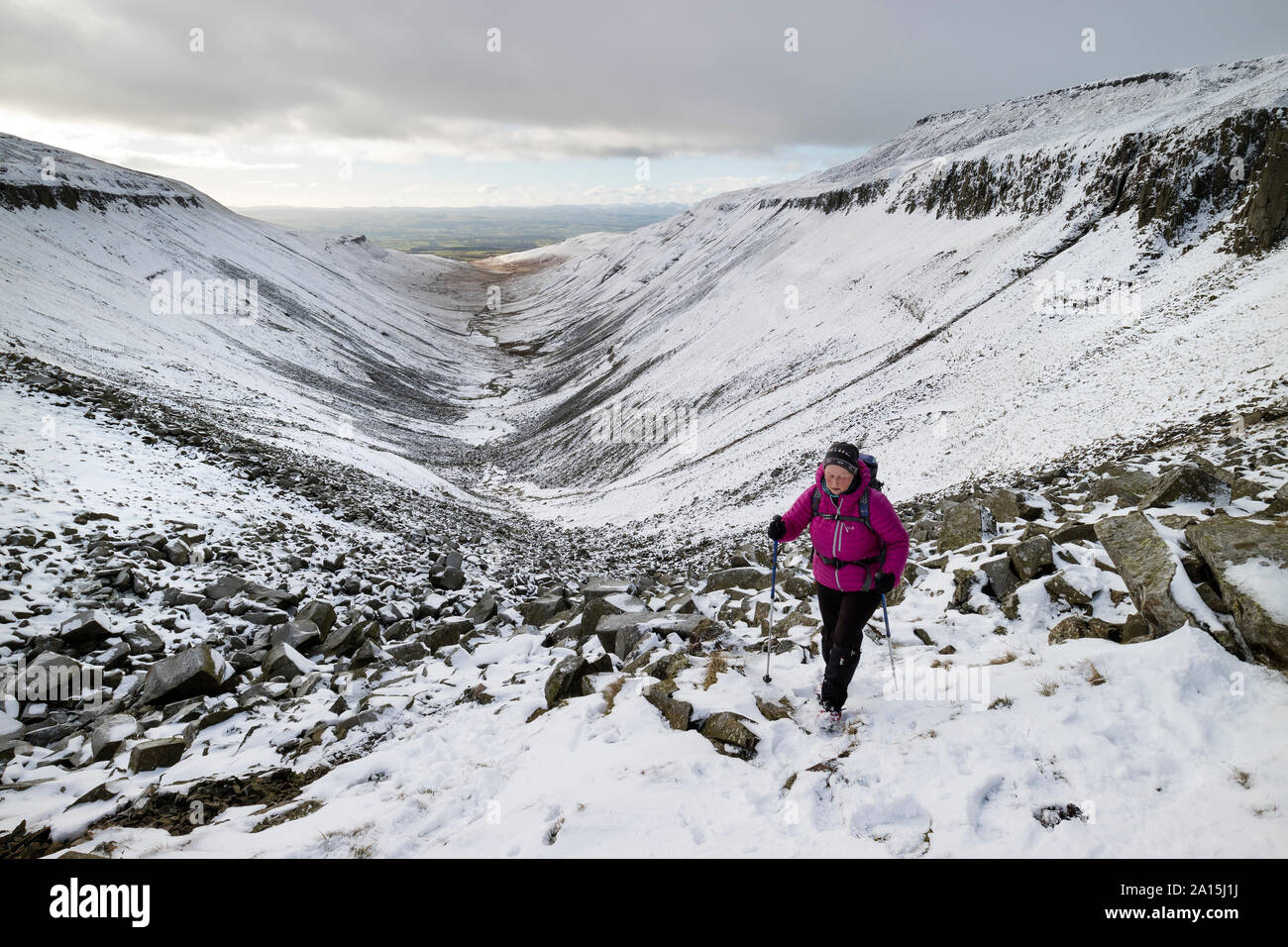 Walker Making Their Way up to High Cup Nick in Winter, Cumbria, UK Stock Photo