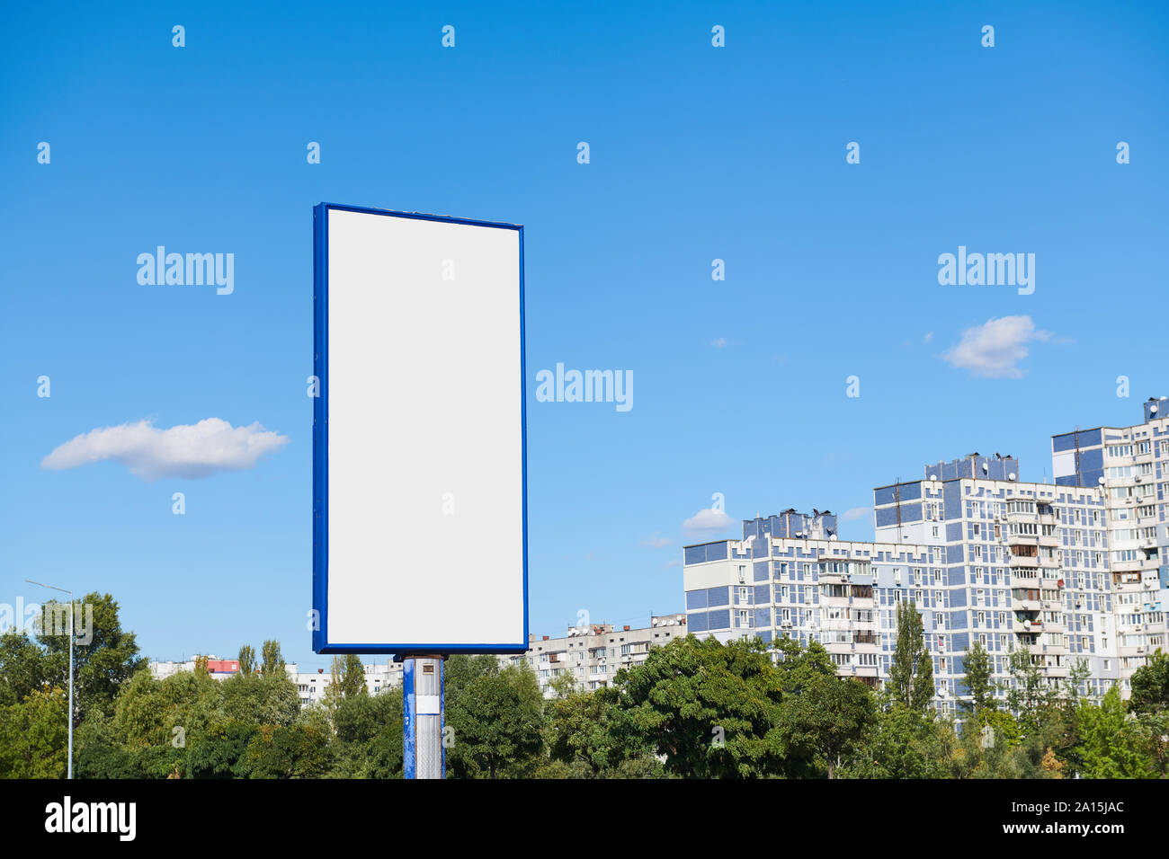Big vertical billboard with copy space on urban background against blue
