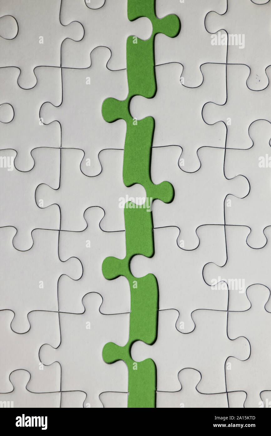 Missing jigsaw puzzle pieces. Business concept. Fragment of a folded white jigsaw  puzzle and a pile of uncombed puzzle elements against the background Stock  Photo - Alamy
