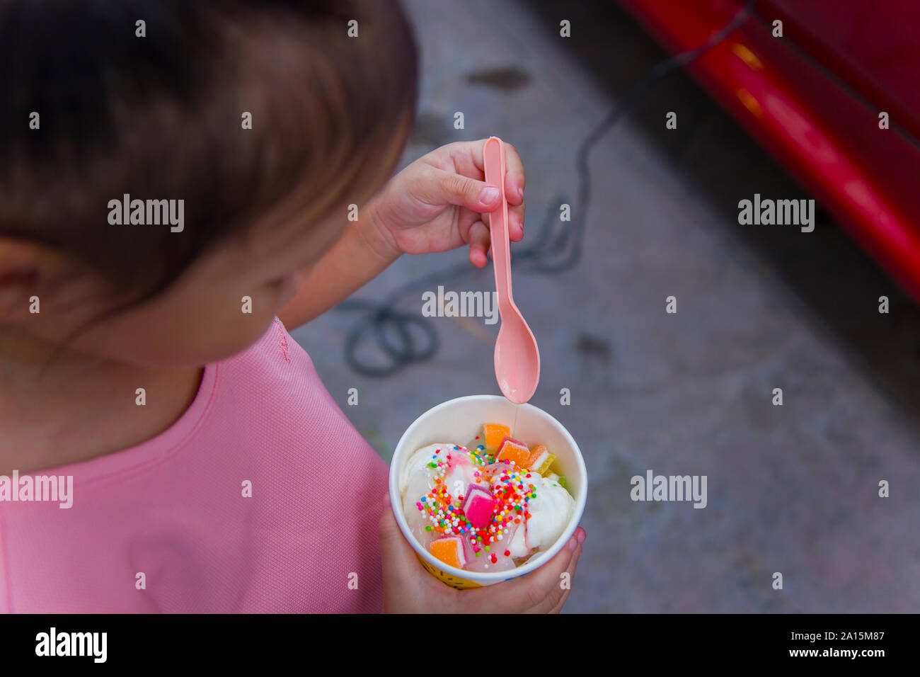 Thai/Asian cute little kids eating Ice cream in a cup or mango bar/candy.  High resolution image gallery. Stock Photo