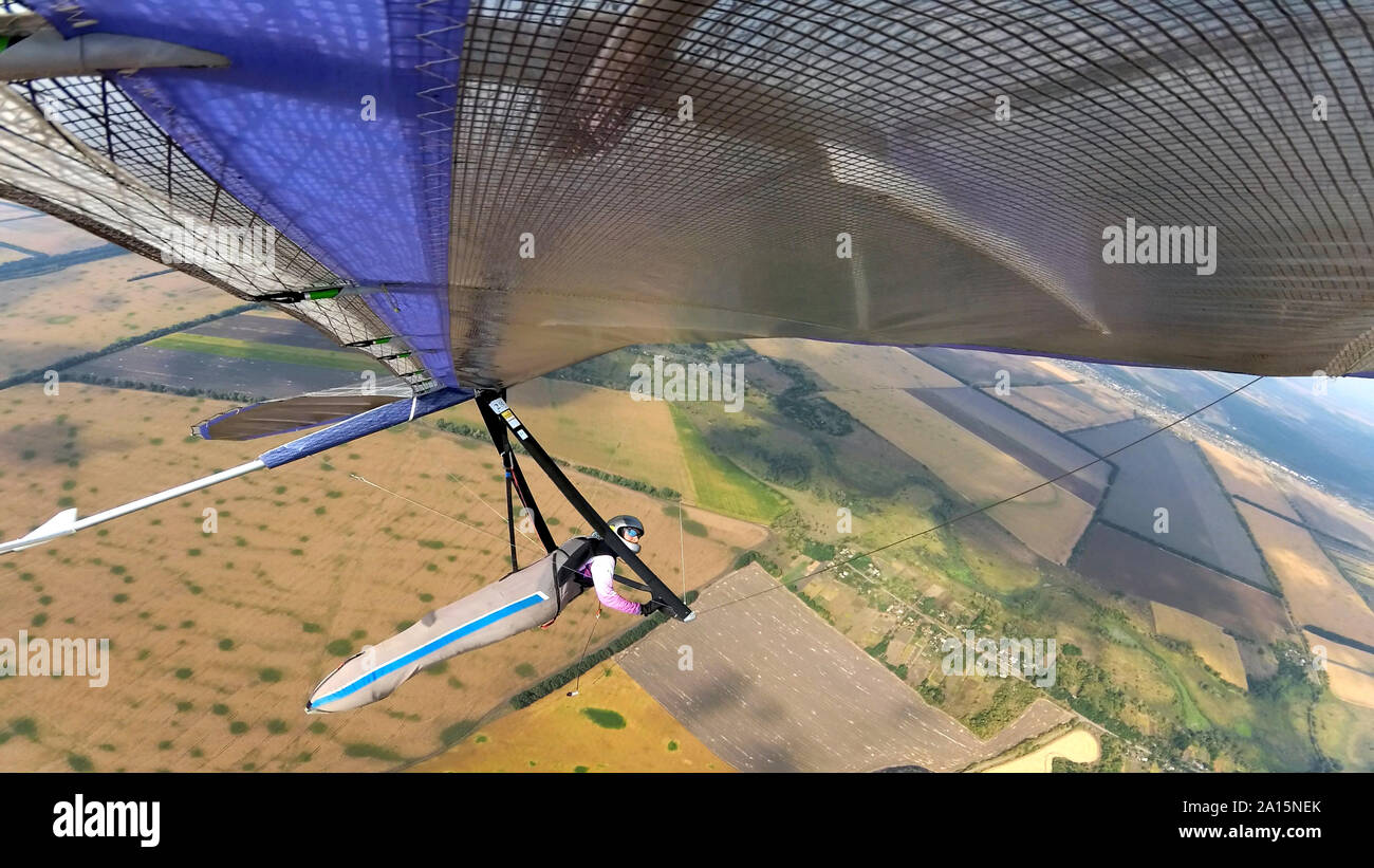 Fearless hang glider pilot fly high above terrain. Photo from the wing Stock Photo