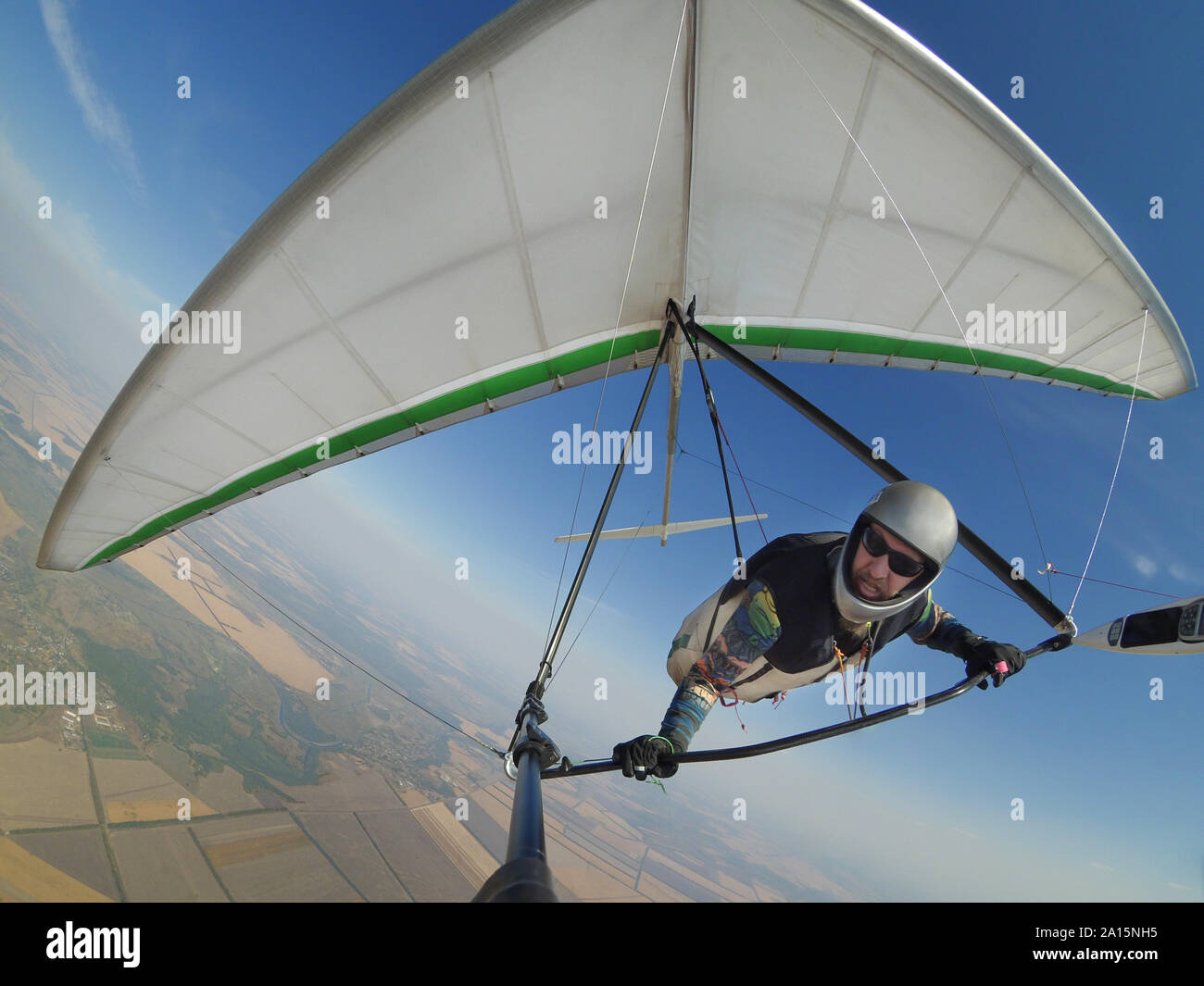 Pilot controls his hang glider wing on hign altitude. Extreme sport action shot Stock Photo