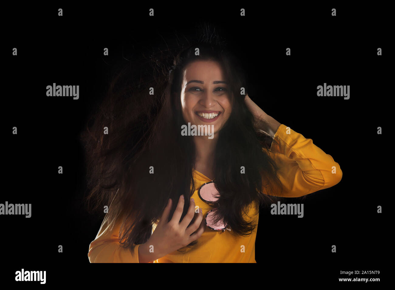 Portrait of smiling woman over black background Stock Photo