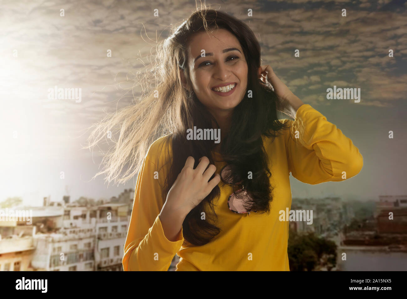 Portrait of smiling woman on urban rooftop at sunset Stock Photo
