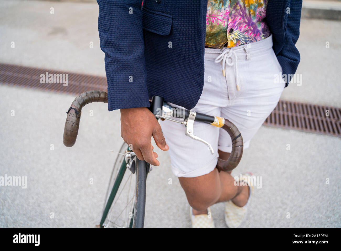 Close-up of stylish man leaning on bicycle Stock Photo