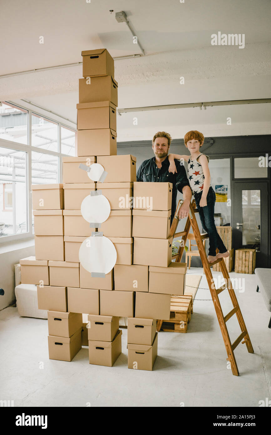 Portrait of father and son playing together with rocket built of ...