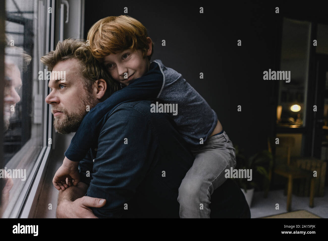 Father and son hanging out at home on rainy day Stock Photo