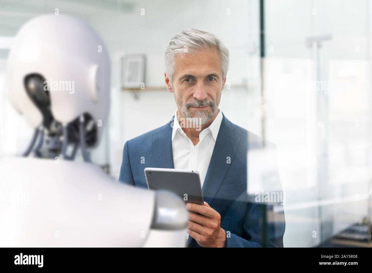 Businessman using digital device to control robot Stock Photo