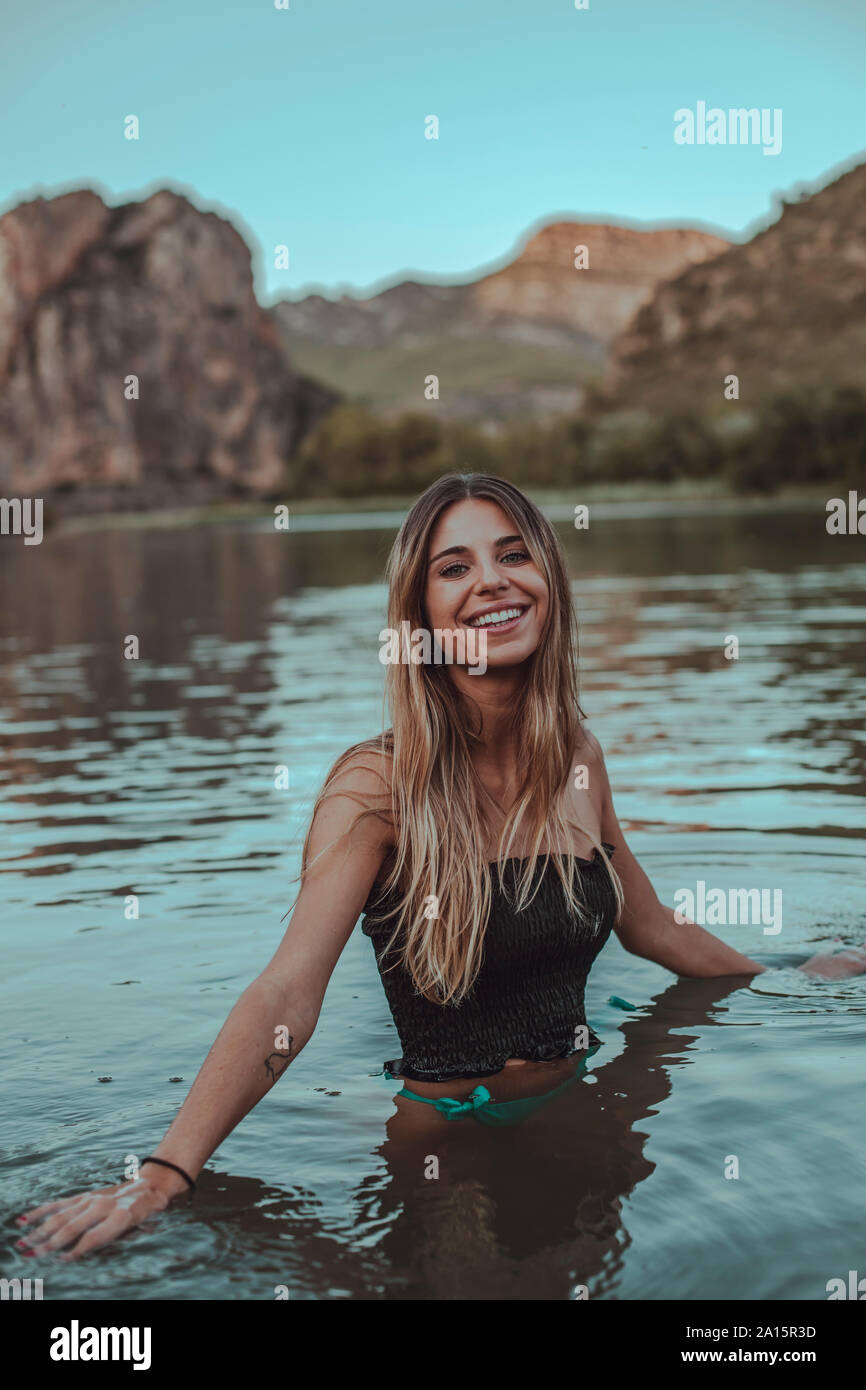 Young blond woman bathing in a lake in summer, in the evening Stock Photo