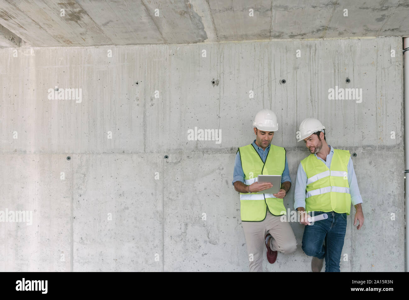 Two workers using tablet on construction site Stock Photo