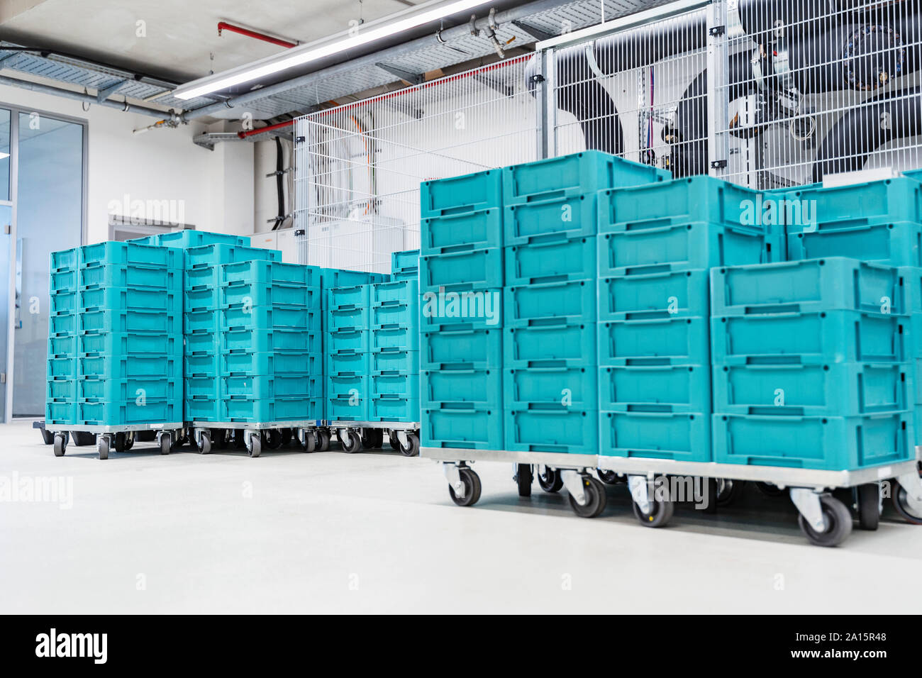 Turquoise colored containers inside modern factory warehouse, Stuttgart, Germany Stock Photo