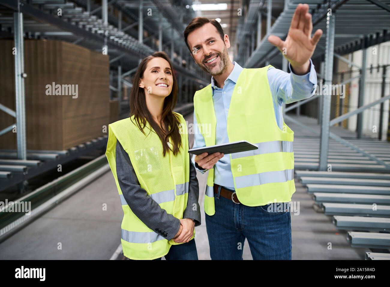 Colleagues wearing reflective vests with tablet in factory Stock Photo