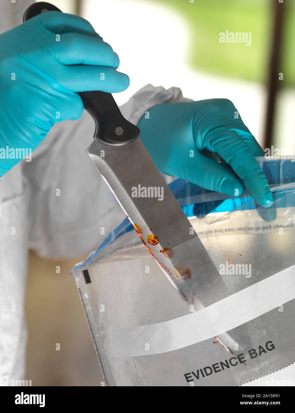 Forensic scientist bagging a knife taken from a violent crime scene Stock Photo