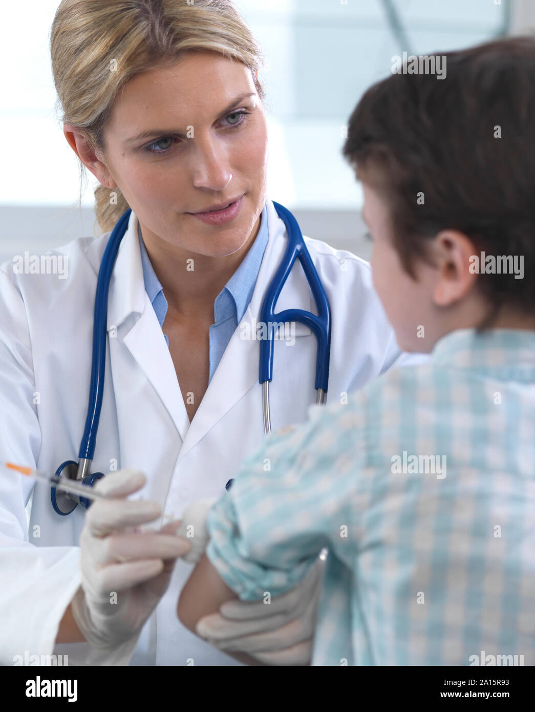 Female doctor giving a young boy a vaccination in the clinic Stock Photo