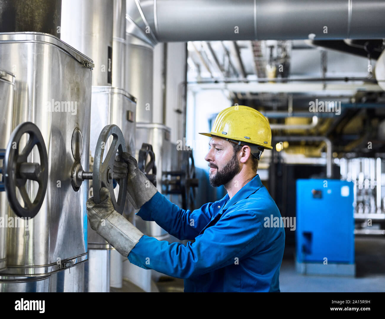 Technician turning a valve Stock Photo Alamy