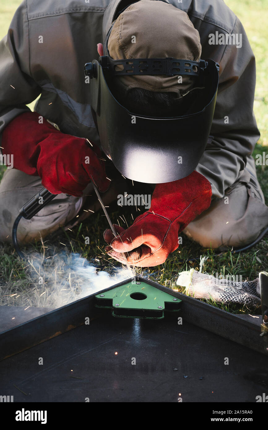 Man welding metal in his backyard Stock Photo