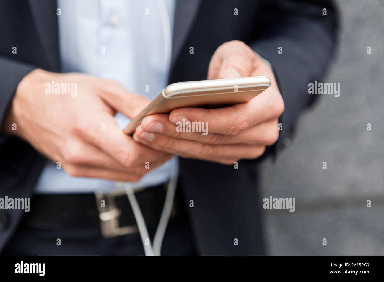 Hands of businessman holding mobile phone, close-up Stock Photo