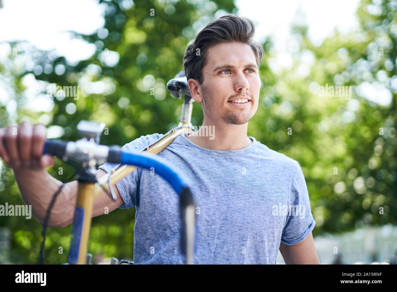 Portrait of man carrying bicycle on his shoulders Stock Photo