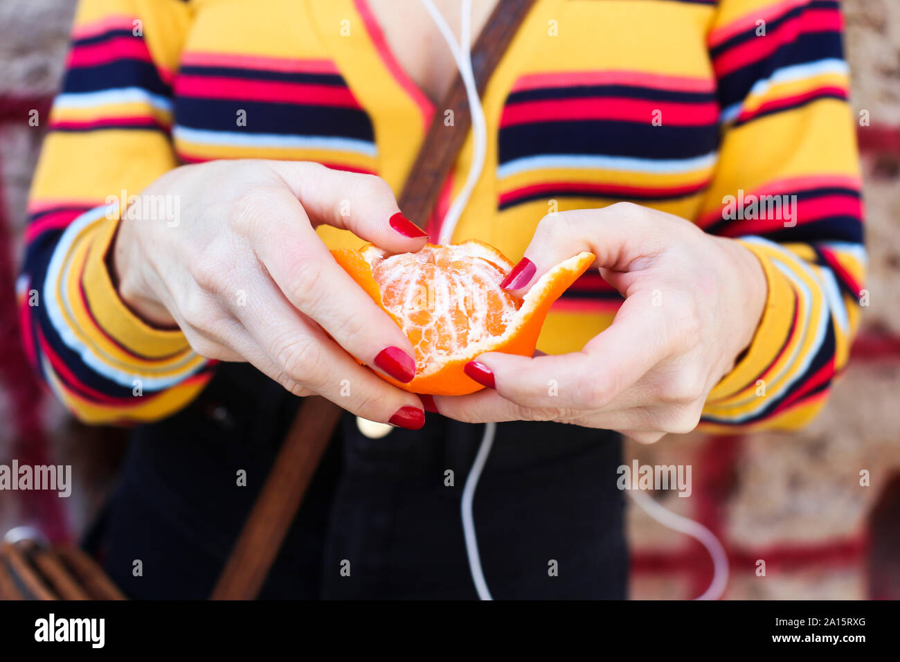 Woman's hands peeling tangerine, close-up Stock Photo