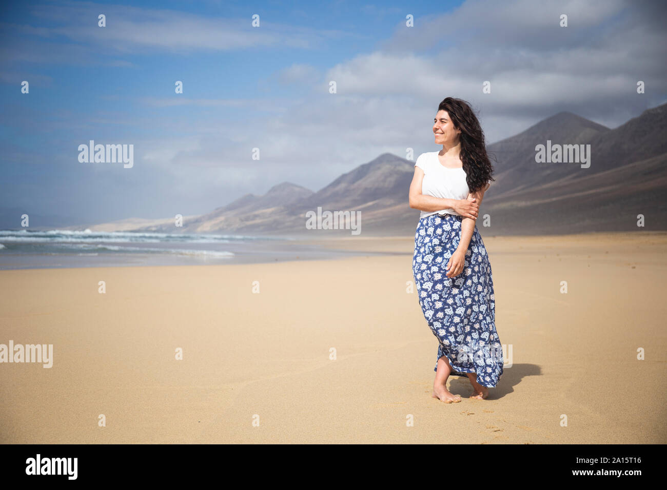 Happy woman standing on the beach looking at distance hi-res stock ...