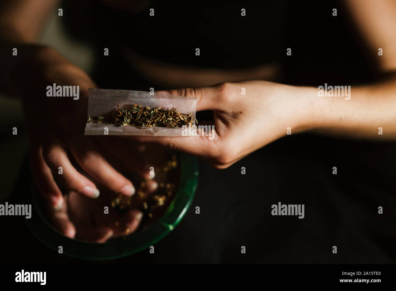 Young woman rolling a joint at home Stock Photo
