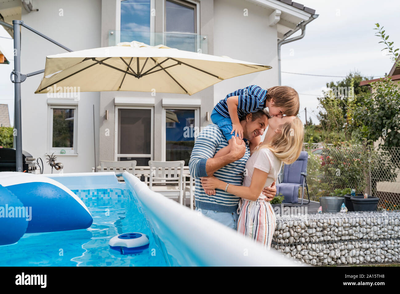 Father with wife carrying son on shoulders in garden Stock Photo