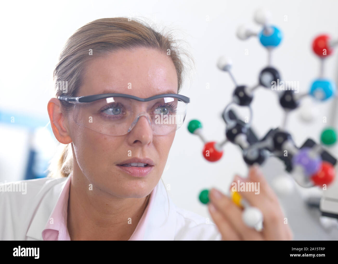 Scientist understanding a chemical formula using a ball and stick molecular model Stock Photo