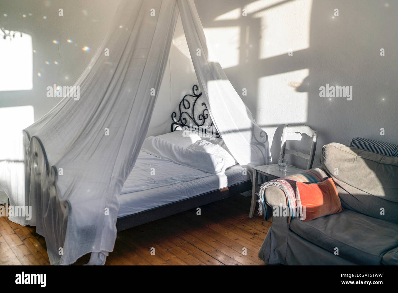 Domestic room with canopy bed and couch Stock Photo