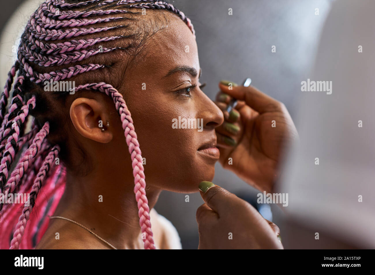 Visagiste applying makeup on young woman's face Stock Photo